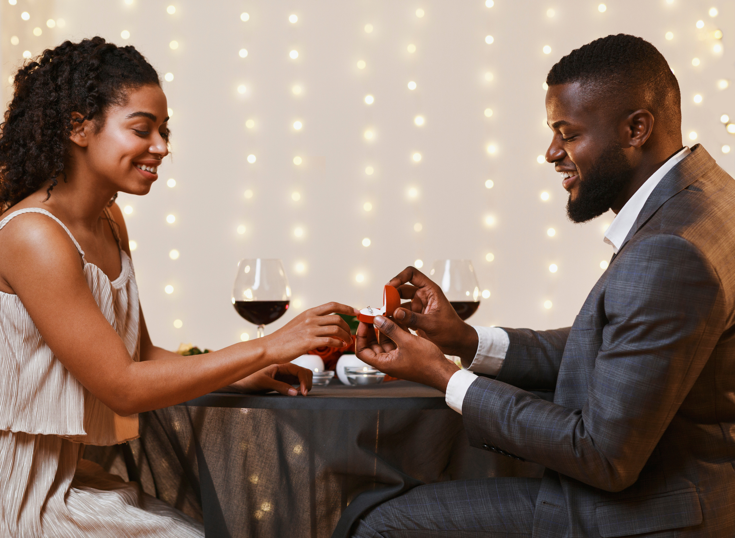 Young black couple getting engaged in restaurant